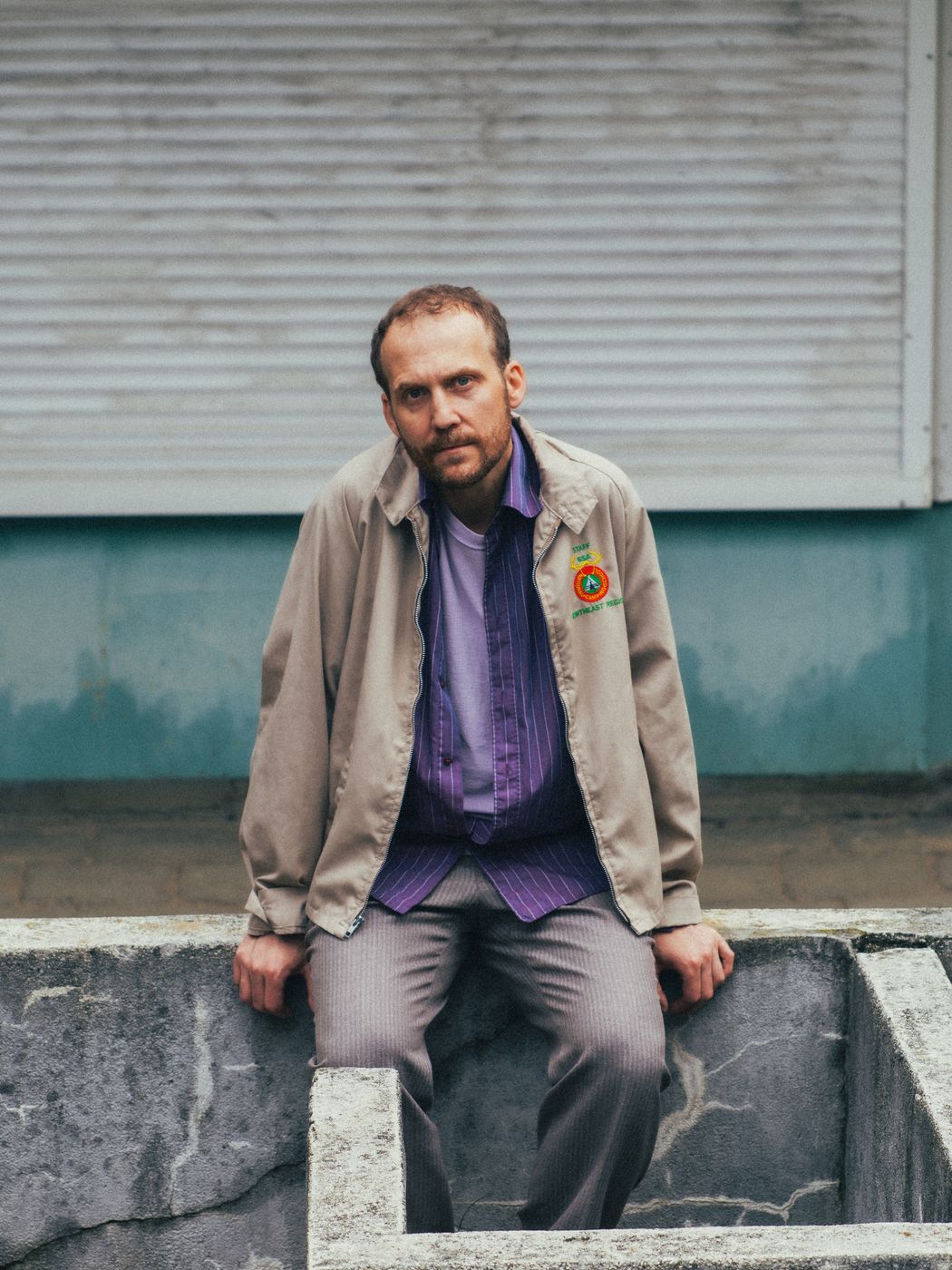 Piotr Kurek seated on a concrete ledge