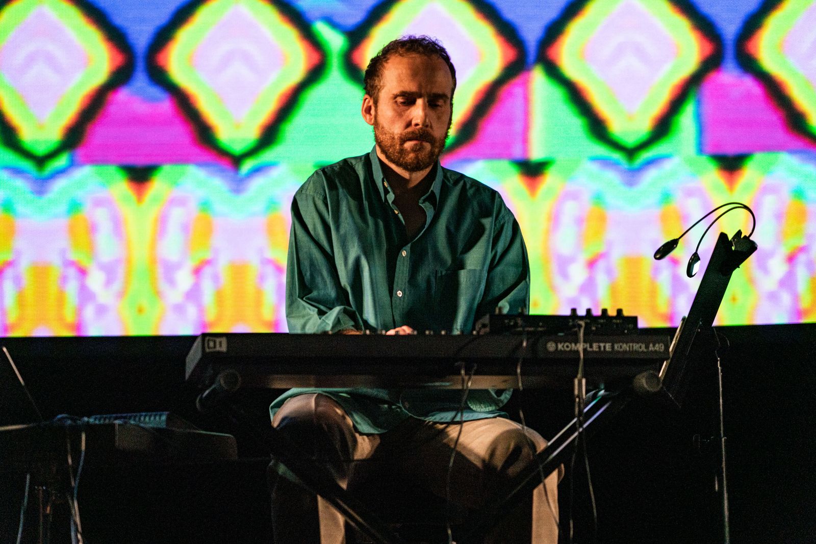 Piotr Kurek at the keyboard in front of live visuals